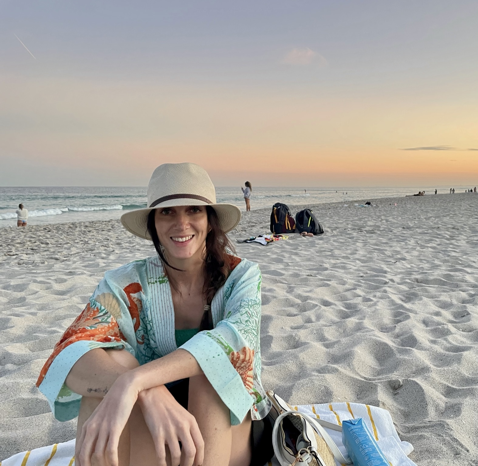 Charlotte, founder of Lumen, on the beach at sunset